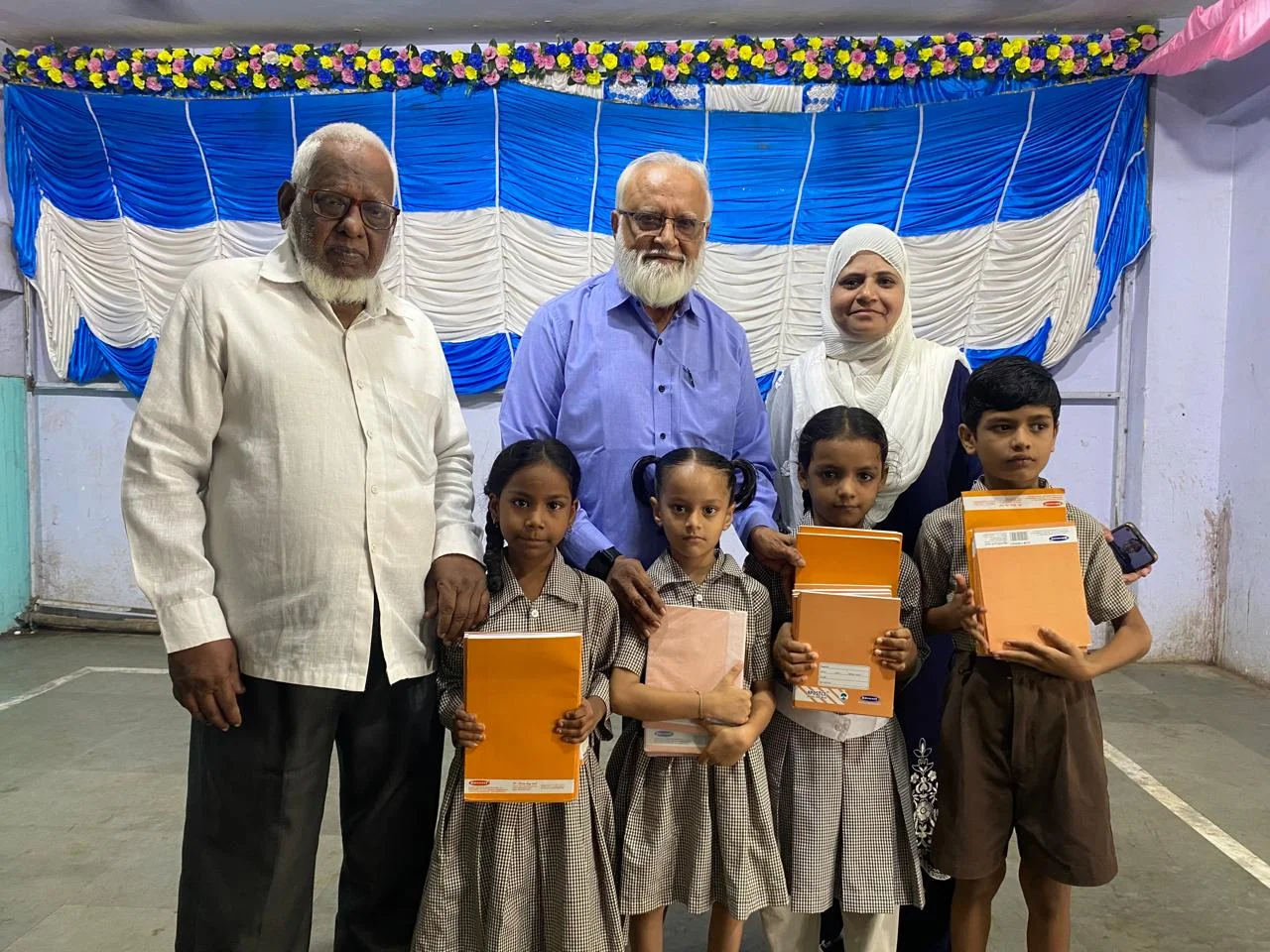 Students Proudly Displaying New Notebooks with BUES Leadership